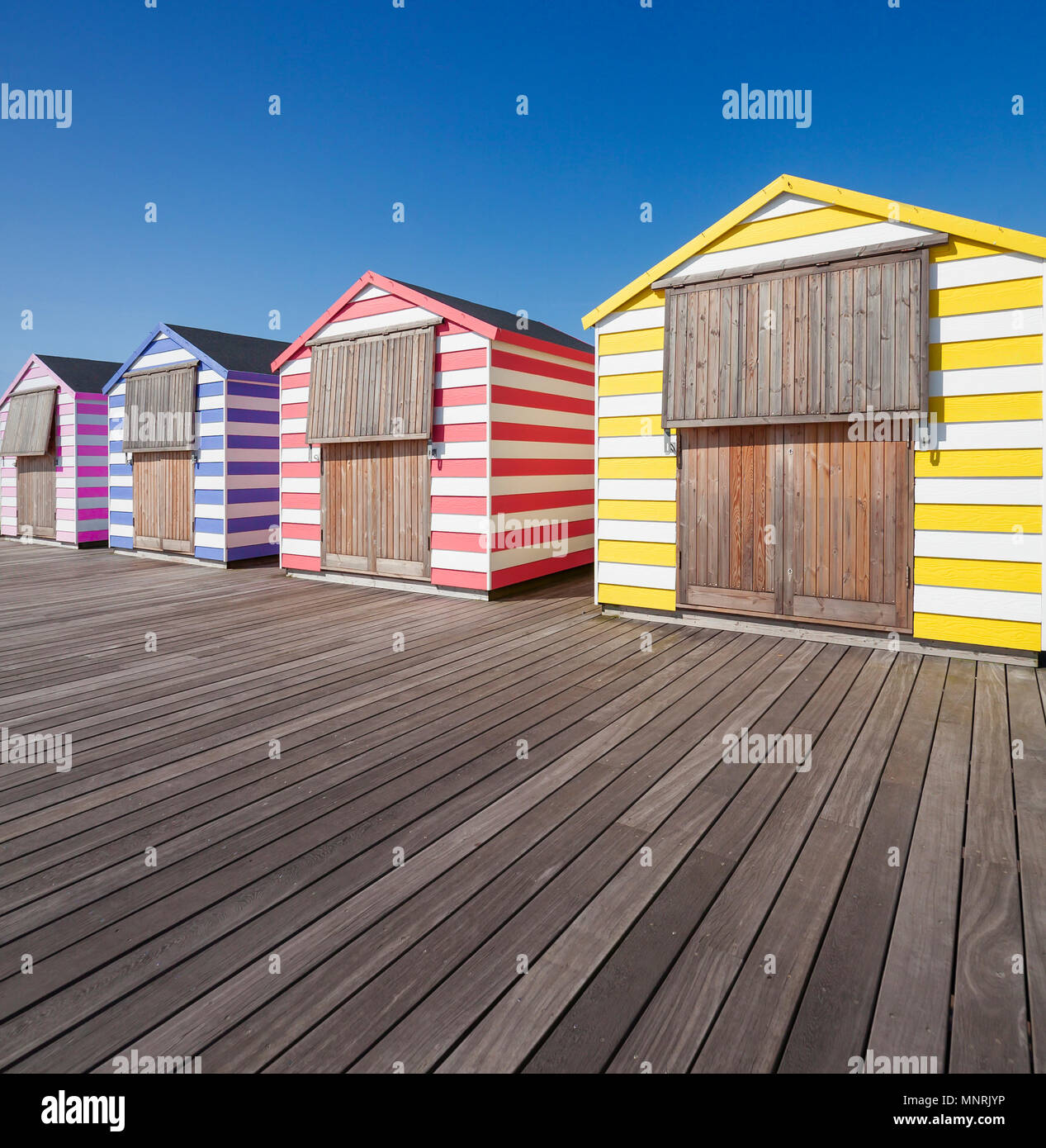 Colourful beach huts Hastings Pier. Stock Photo