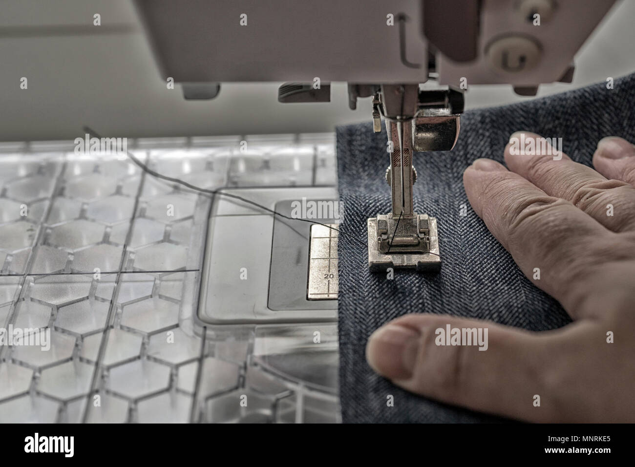 sewing machine sews denim fabric Stock Photo Alamy