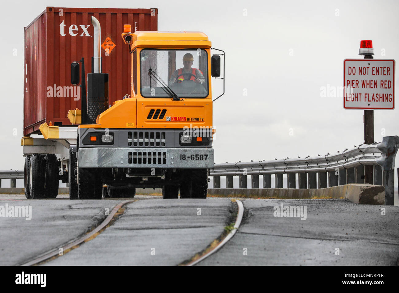 A U.S. Army Reserve Soldier transports a Twenty-foot equivalent unit container across a pier to a staging area during Operation Trans Mariner 18 West at Military Ocean Terminal Concord, California, Mar. 2, 2018. Trans Mariner 18 West is a real-world strategic mission utilizing U.S. Army Reserve and Active component Soldiers to conduct Port Operations allowing Army materiel and munitions containers for travel onward. Stock Photo