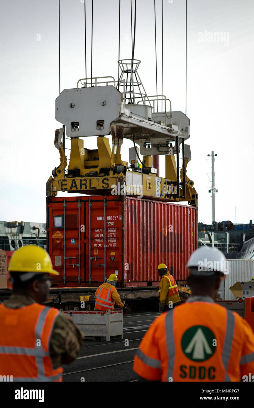 U.S. Army Reserve Soldiers observe the transport of a Twenty-foot equivalent unit container during Operation Trans Mariner 18 West at Military Ocean Terminal Concord, California, Mar. 2, 2018. Trans Mariner 18 West is a real-world strategic mission utilizing U.S. Army Reserve and Active component Soldiers to conduct Port Operations allowing Army materiel and munitions containers for travel onward. Stock Photo