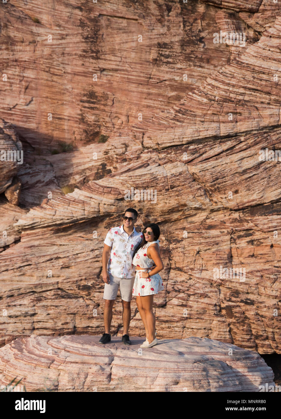 Couple poses in front of cross-bedded sandstone, Calico Hills, Red Rock Canyon National Conservation Area, Las Vegas, Nevada Stock Photo