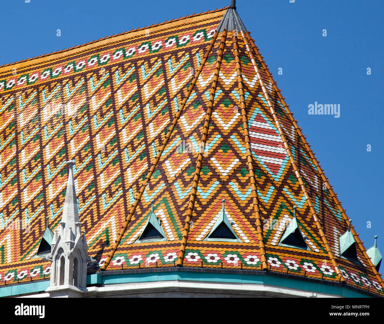 The ornate ceramic tile roof of the Matthias Church crowns the Fisherman's Bastion on Buda Hill, Budapest, Hungary. Stock Photo