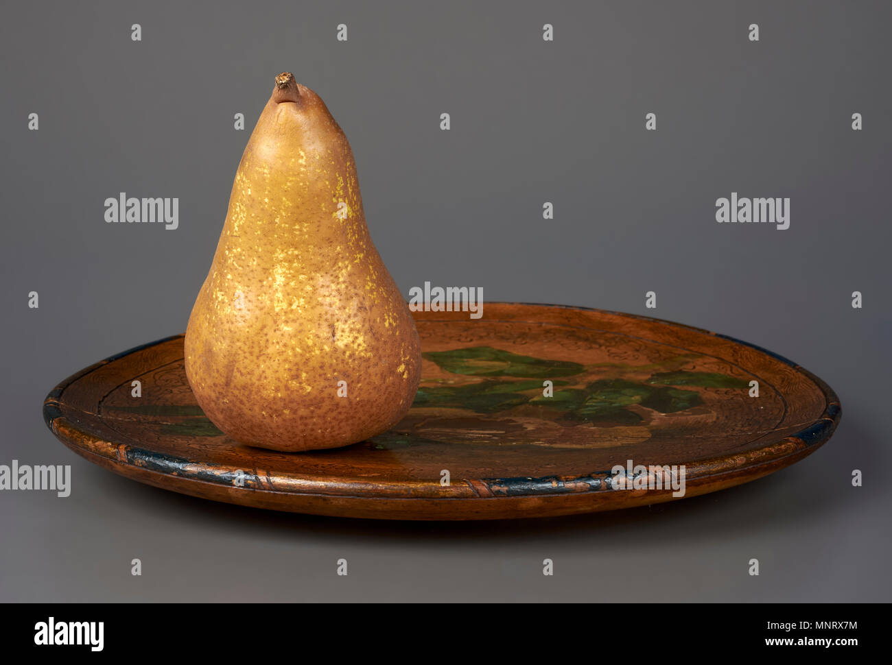 a pear  on a plate on a gray background Stock Photo