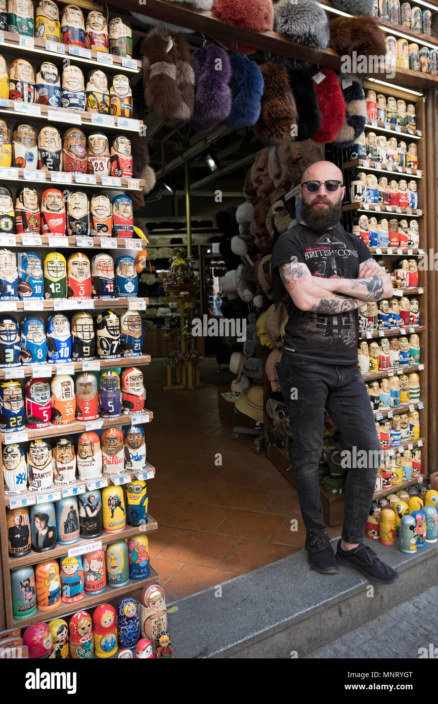 A merchant in the Old Town section of Prague at his gift shop which sells nesting dolls with figures of sports heroes. Czech Republic. Stock Photo