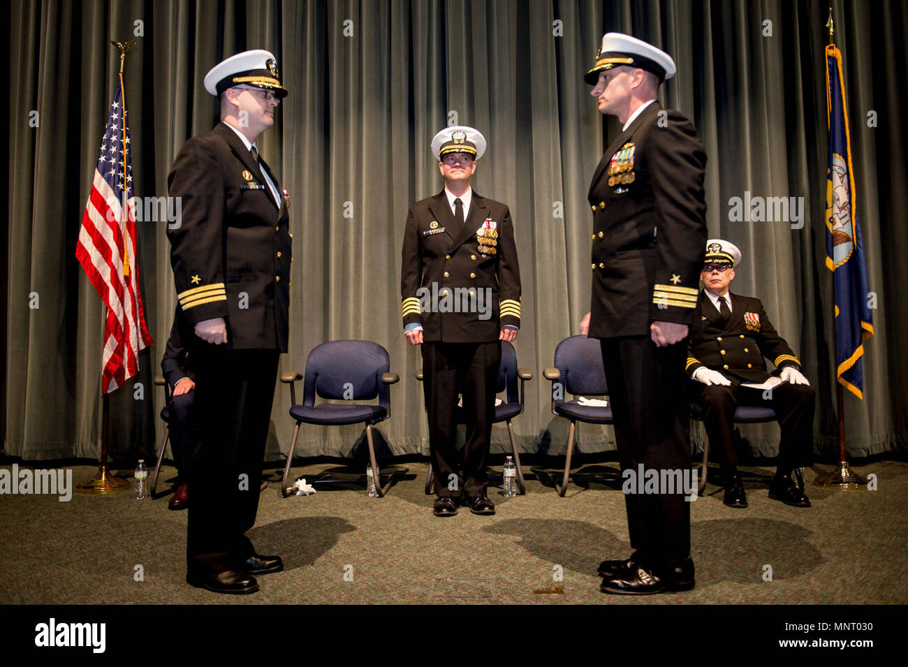 Cmdr. Andrew Clark, left, requests to be relieved of command by Capt. Nicholas R. Tilbrook, Submarine Squadron 17, center, during a change of command ceremony for the Gold crew of the Ohio-class ballistic missile submarine USS Pennsylvania (SSBN 735). Clark turned over command to Cmdr. Roger C. Ferguson, during the ceremony held at the Keyport Undersea Museum, March 15, 2018. Stock Photo