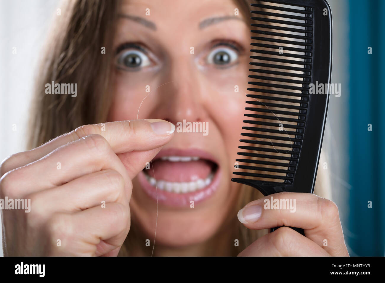 Shocked Woman Suffering From Hair Loss Problem Stock Photo