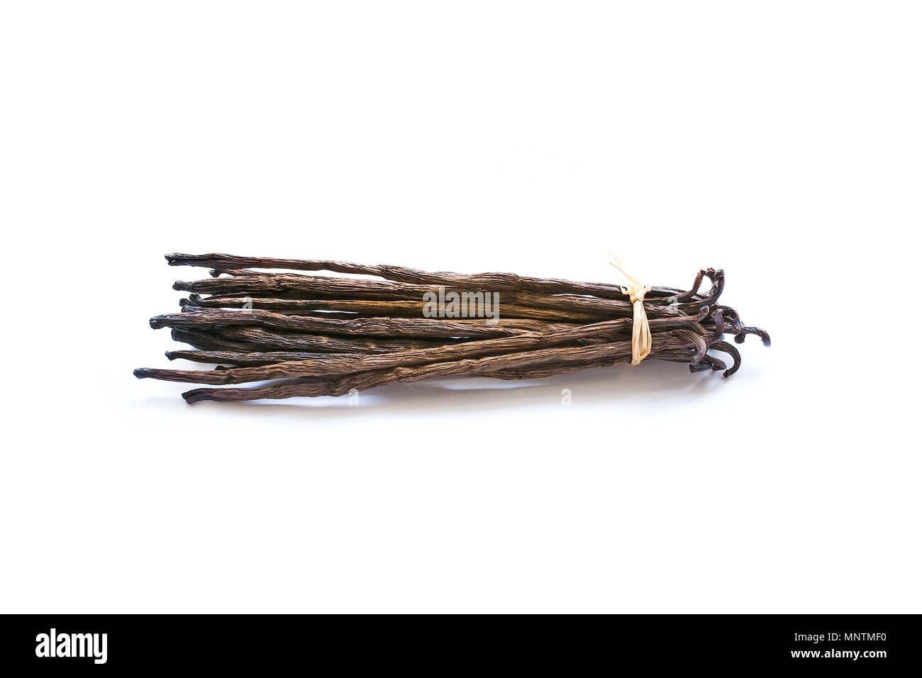 Vanilla pods with straw bow isolated on white. Stock Photo