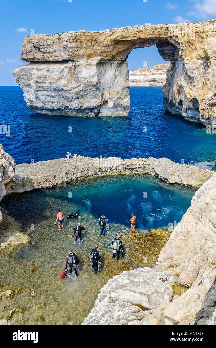 scuba divers and swimmers at Blue Hole, Azure Window, or Dwejra Window in background, Gozo