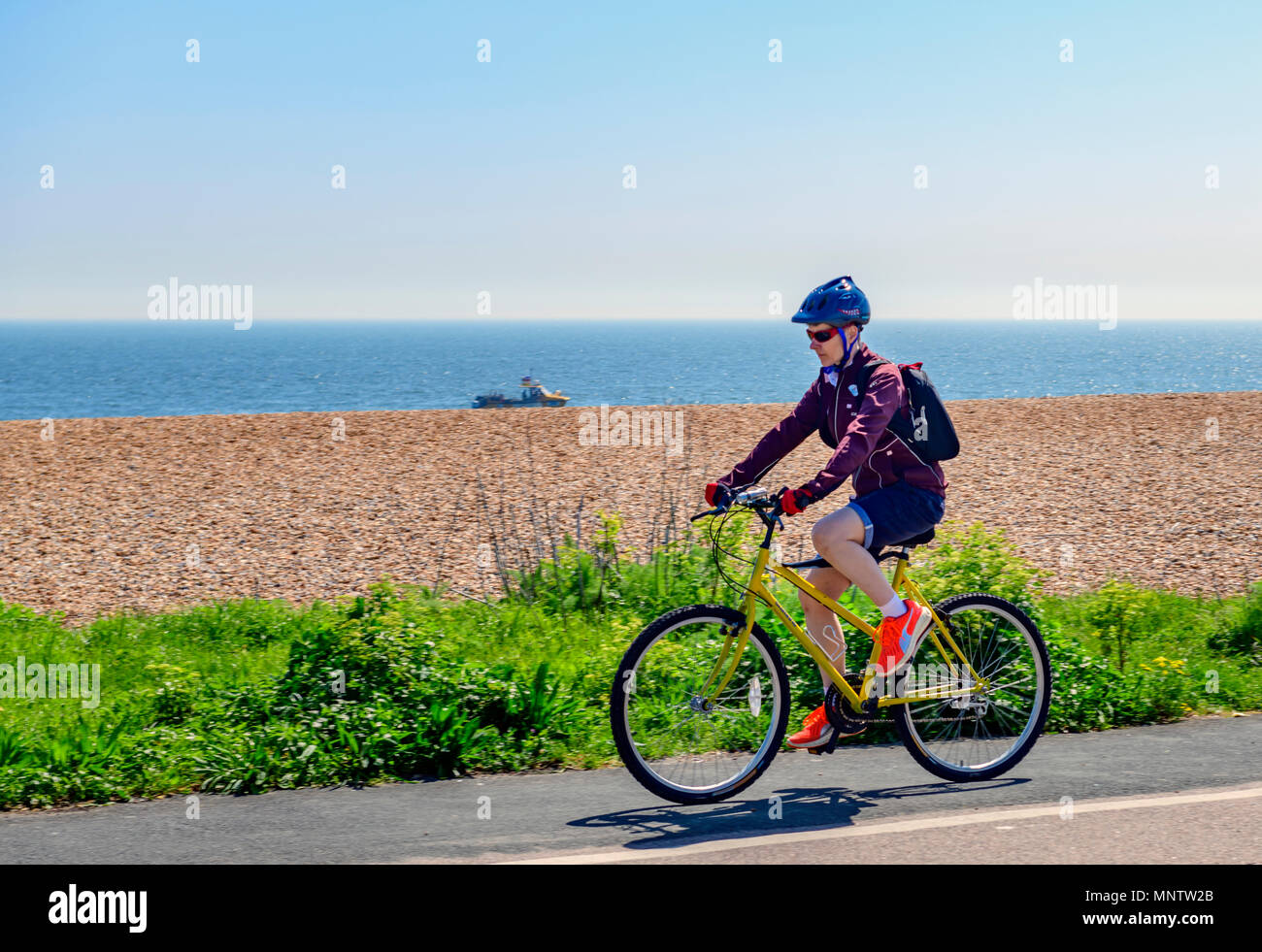 Female cyclist using the cycle path along Deal seafront Stock Photo