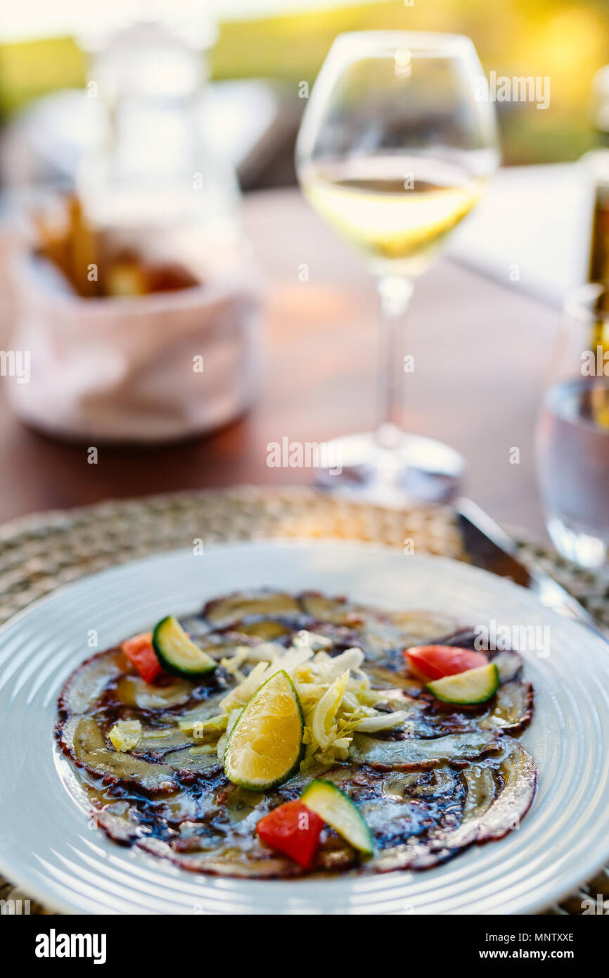 Octopus carpaccio served with wine for lunch Stock Photo
