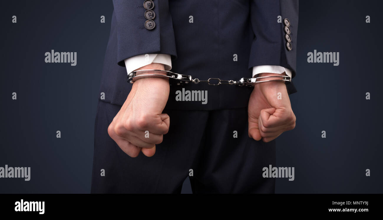 Close now arrested men hand with dark background and handcuffs  Stock Photo