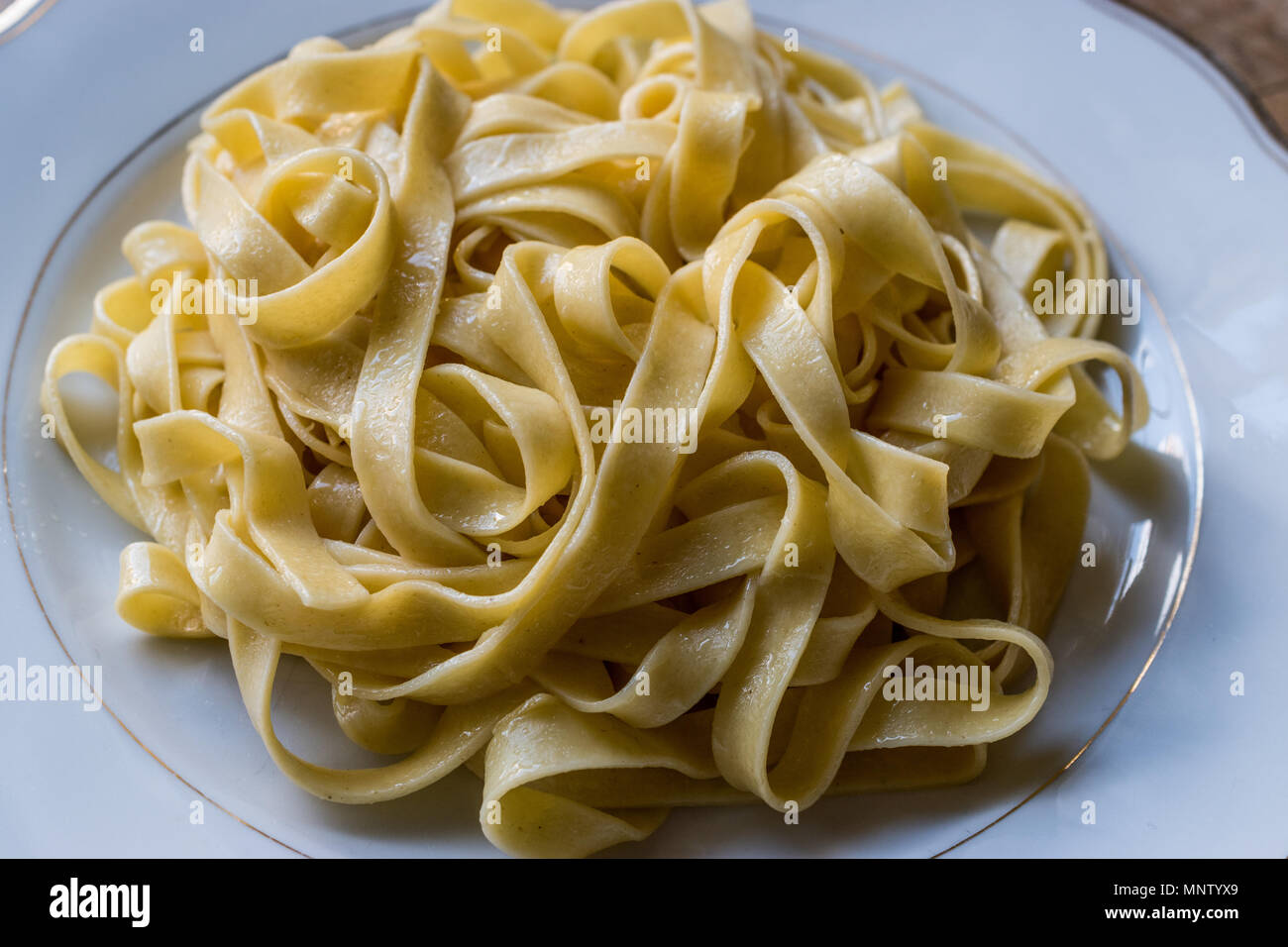 Plain Tagliatelle Pasta in white plate. Organic Spaghetti Stock Photo