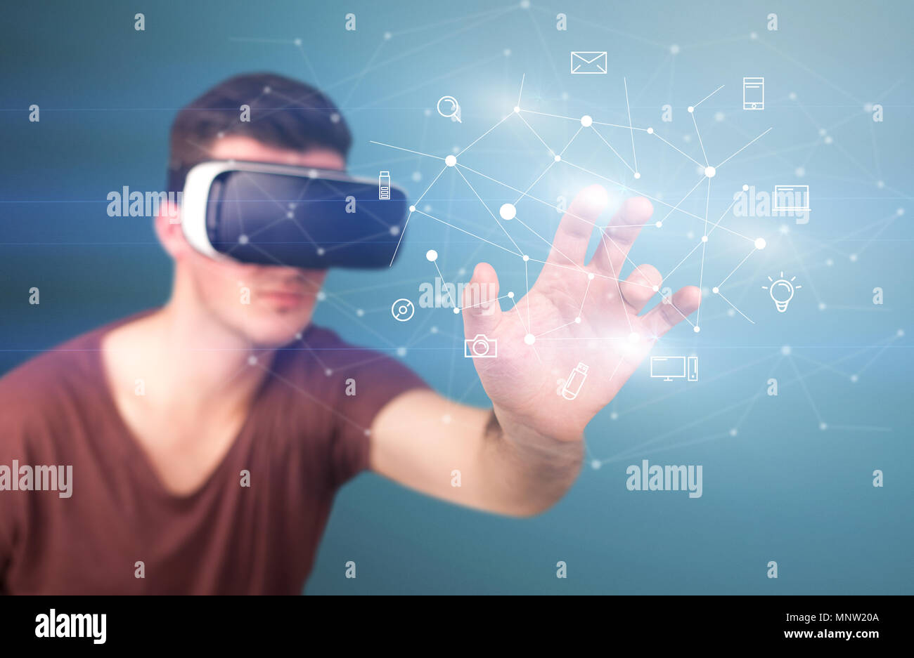 Young impressed man wearing virtual reality goggles with mixed media ...