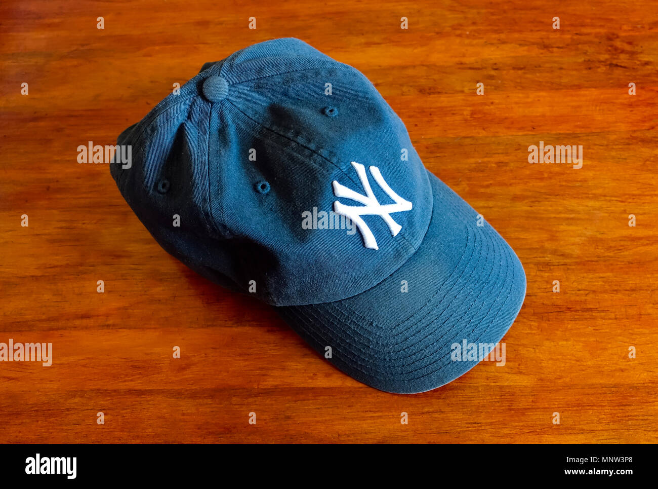 A New York Yankees baseball cap on a wooden table Stock Photo