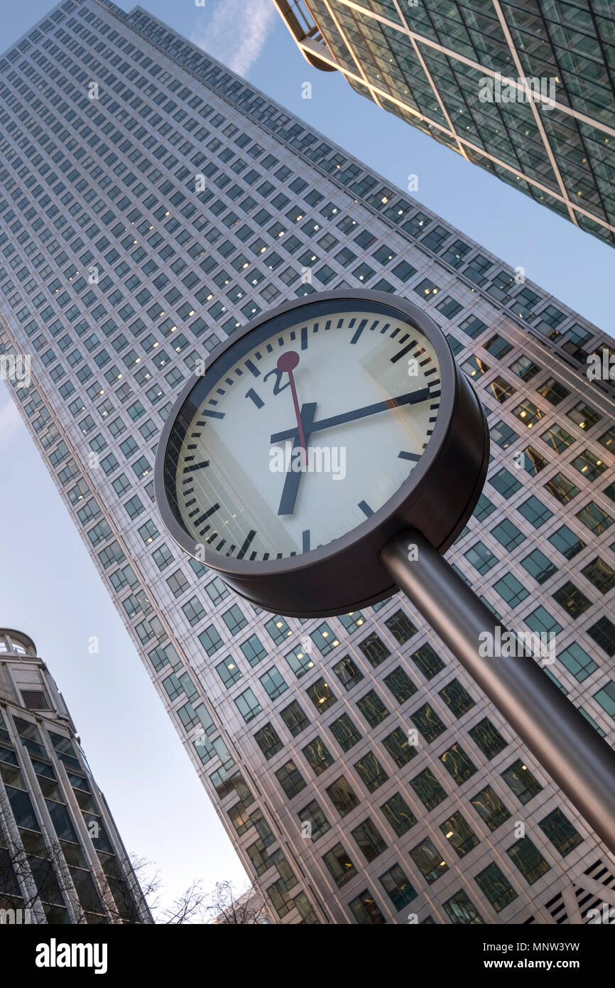 Canary Wharf Clock backed by 1 Canada Square Building, Reuters Plaza, Canary Wharf, London, England, UK Stock Photo