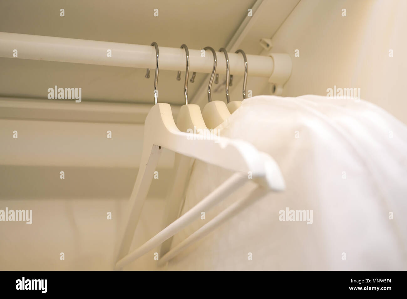 row of men and women shirts on the hanger, hanging in the wardrobe Stock Photo