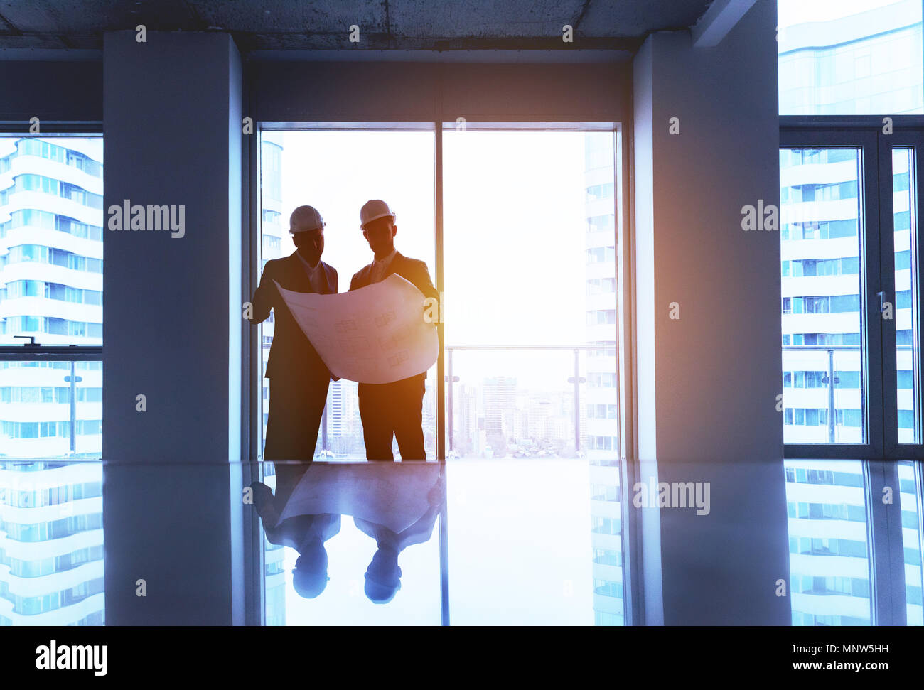 Engineer and businessman with plan in empty office Stock Photo
