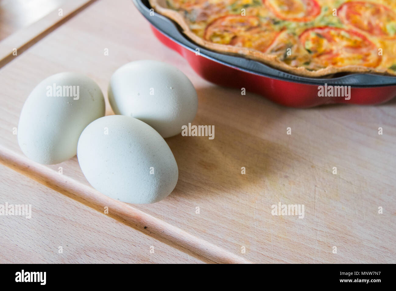 fresh quiche with green eggs, tomatos and spring onions Stock Photo