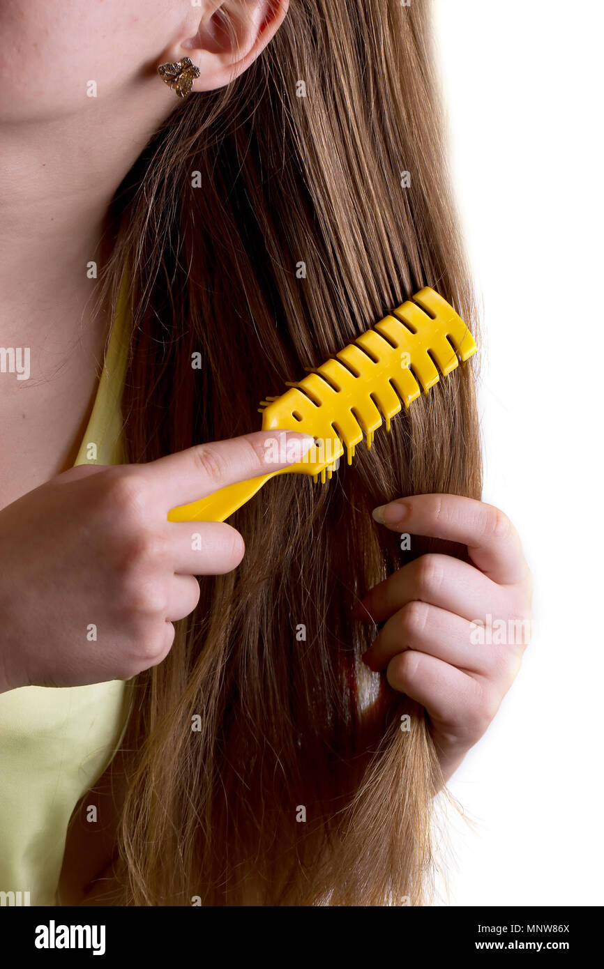 Woman combing her hair comb yellow Stock Photo - Alamy
