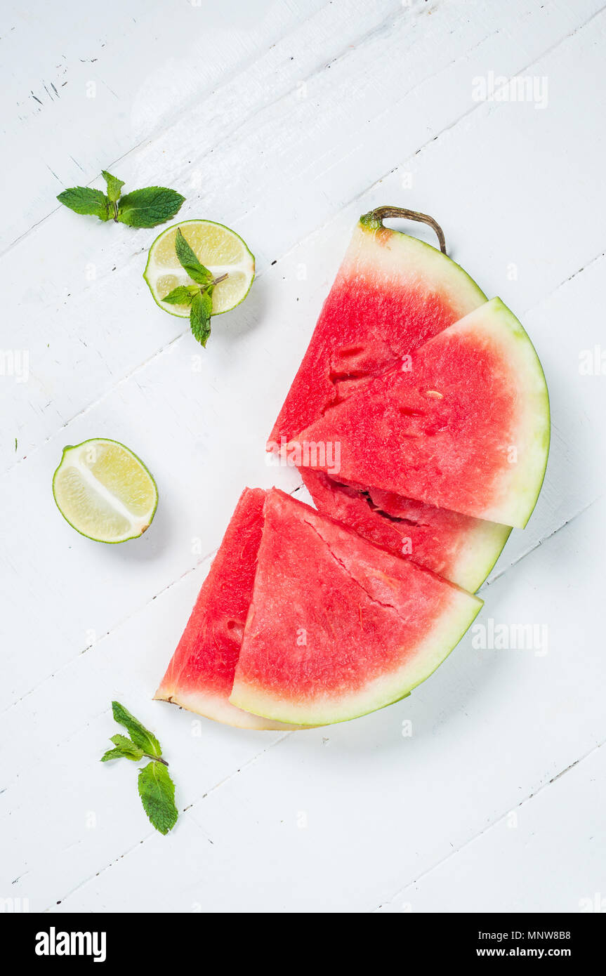 Watermelon slice and lime on rustic wood background. Stock Photo