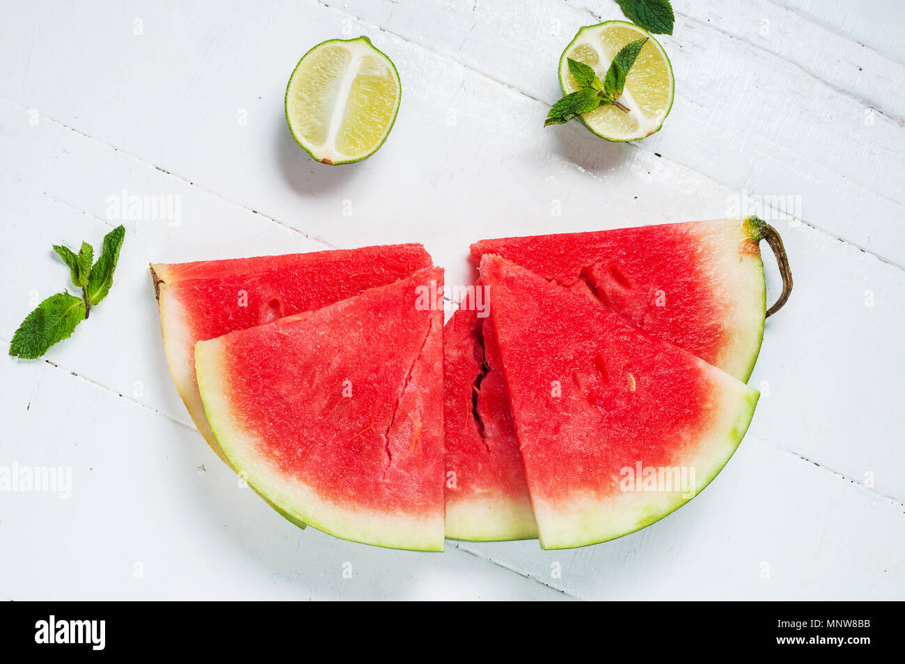 Watermelon slice and lime on rustic wood background. Stock Photo