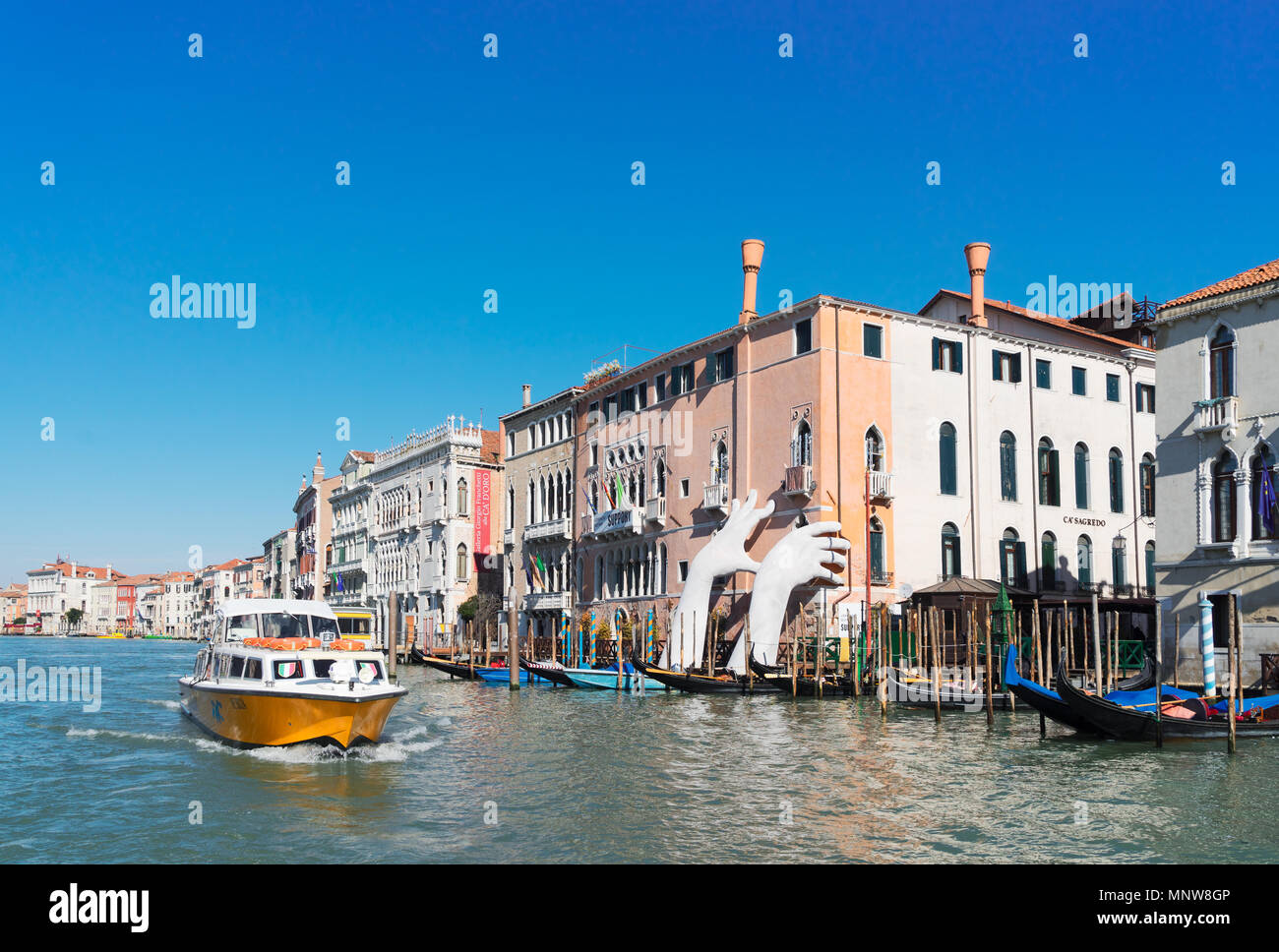 VENICE, ITALY - MARCH 20, 2018: Boatd floting in front of Giant Hands of Venice's Grand Canal in march 20, 2018 Stock Photo
