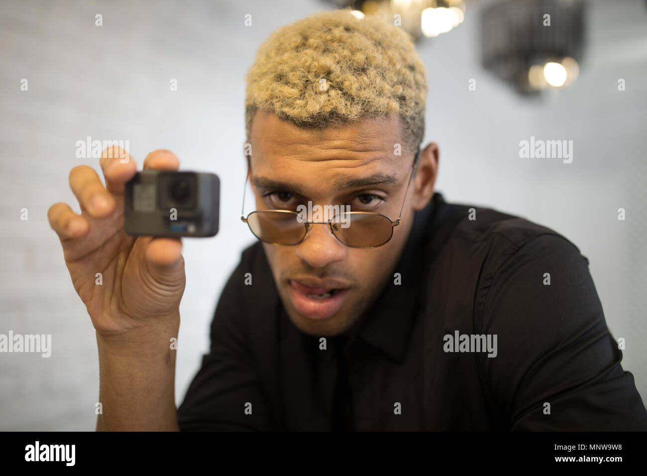 Stylish young man with glasses with camera in hands. Stock Photo