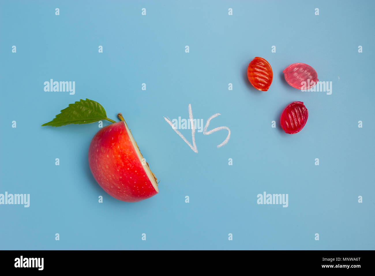 half of an apple and sweet food. unhealthy vs healthy food Stock Photo