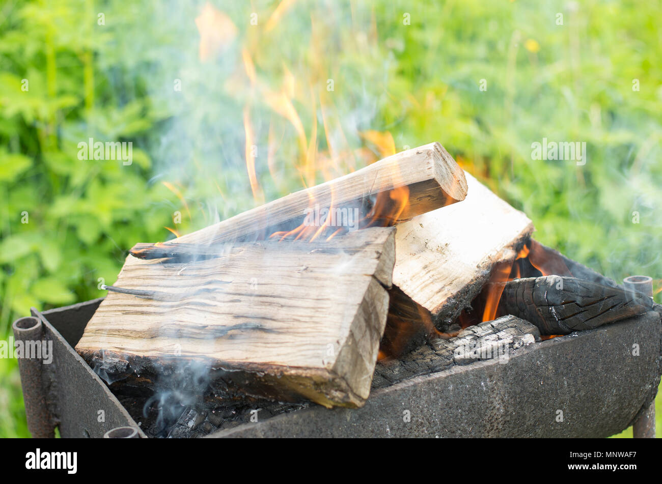Smoky firewood in a brazier gradually turning into coals Stock Photo - Alamy