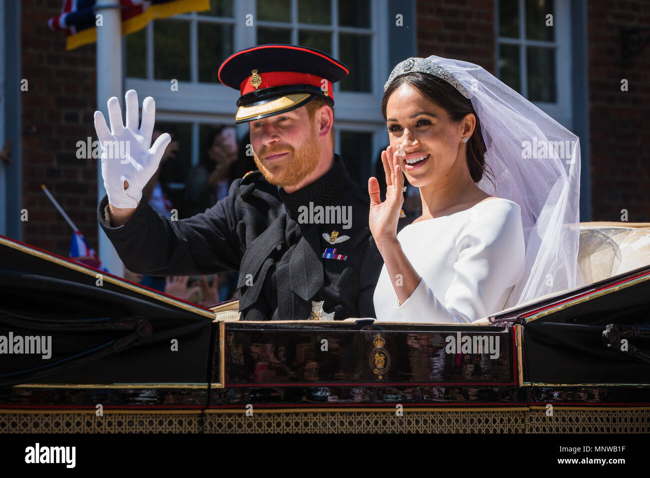 Windsor, UK, 19 May 2018. Prince Harry and his bride Meghan Markle ride around the streets of Windsor in a state Landau greeted by huge crowds cheering and waving flags following their wedding at St Georges Chapel. Before heading back to Windsor castle for their wedding reception. They will now be know as The Duke and Duchess of Sussex Stock Photo