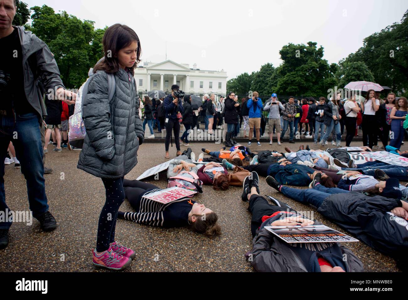 Washington, District of Columbia, USA. 19th May, 2018. A young tourist observes a ''lie-in'' staged by local high school students in front of the White House. The students demonstrated to honor the victims of the Santa Fe High School shooting in Texas and to demand the U.S. president and Congress work to pass gun control legislation. Credit: Erin Scott/ZUMA Wire/Alamy Live News Stock Photo