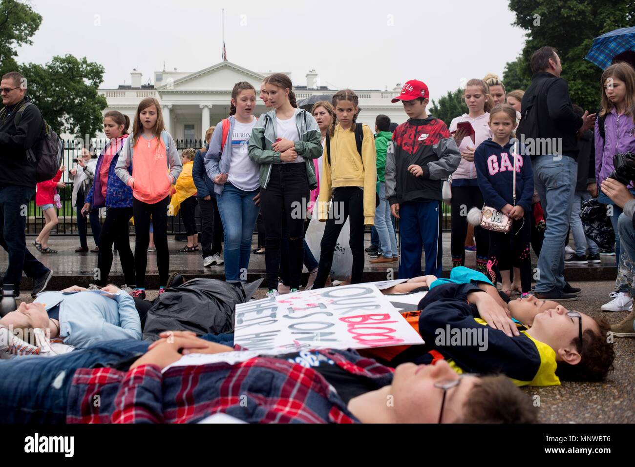Washington, District of Columbia, USA. 19th May, 2018. A group of young tourists observe a ''lie-in'' staged by local high school students in front of the White House. The students demonstrated to honor the victims of the Santa Fe High School shooting in Texas and to demand the U.S. president and Congress work to pass gun control legislation. Credit: Erin Scott/ZUMA Wire/Alamy Live News Stock Photo