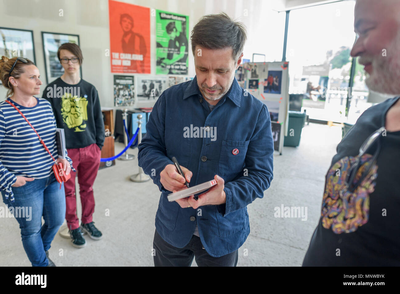 Northwich,Cheshire UK, May 19, 2018. Film actor and director Paddy Considine signs an autograph for a fan at the Charlatans exhibition with his wife Shelley close behind at the North By Northwich fesival, Barons Quay, Northwich, Cheshire, Uk. Credit: Ian Hubball/Alamy Live News Stock Photo