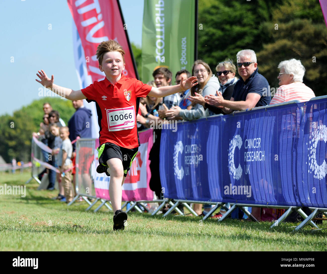 Runners cross the line for Cancer Research UK's Race for Life, Dorchester, UK Credit: Finnbarr Webster/Alamy Live News Stock Photo