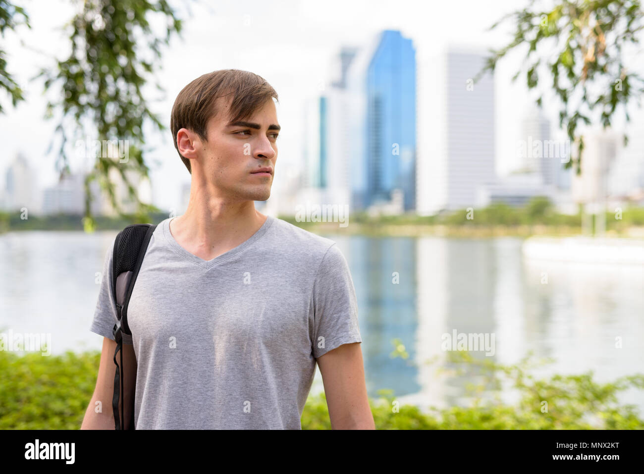 Young handsome man with backpack relaxing at the park Stock Photo