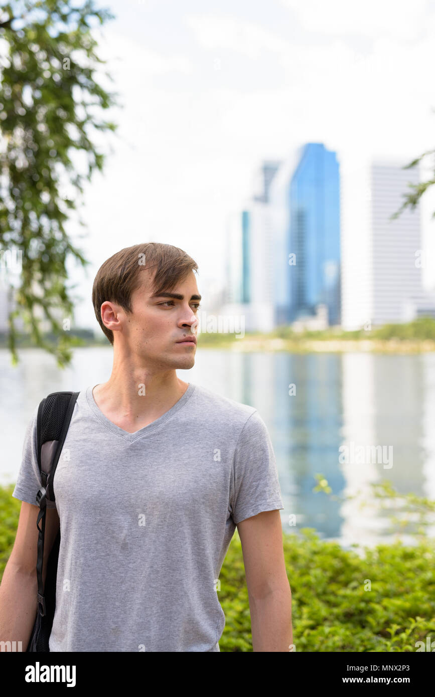Young handsome man with backpack relaxing at the park Stock Photo