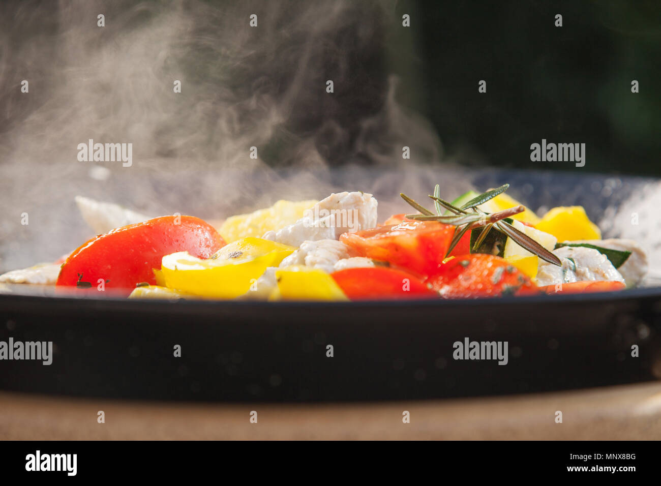 https://c8.alamy.com/comp/MNX8BG/meat-sweet-pepper-and-tomatoes-in-a-hot-pan-coooking-outside-in-the-sun-MNX8BG.jpg