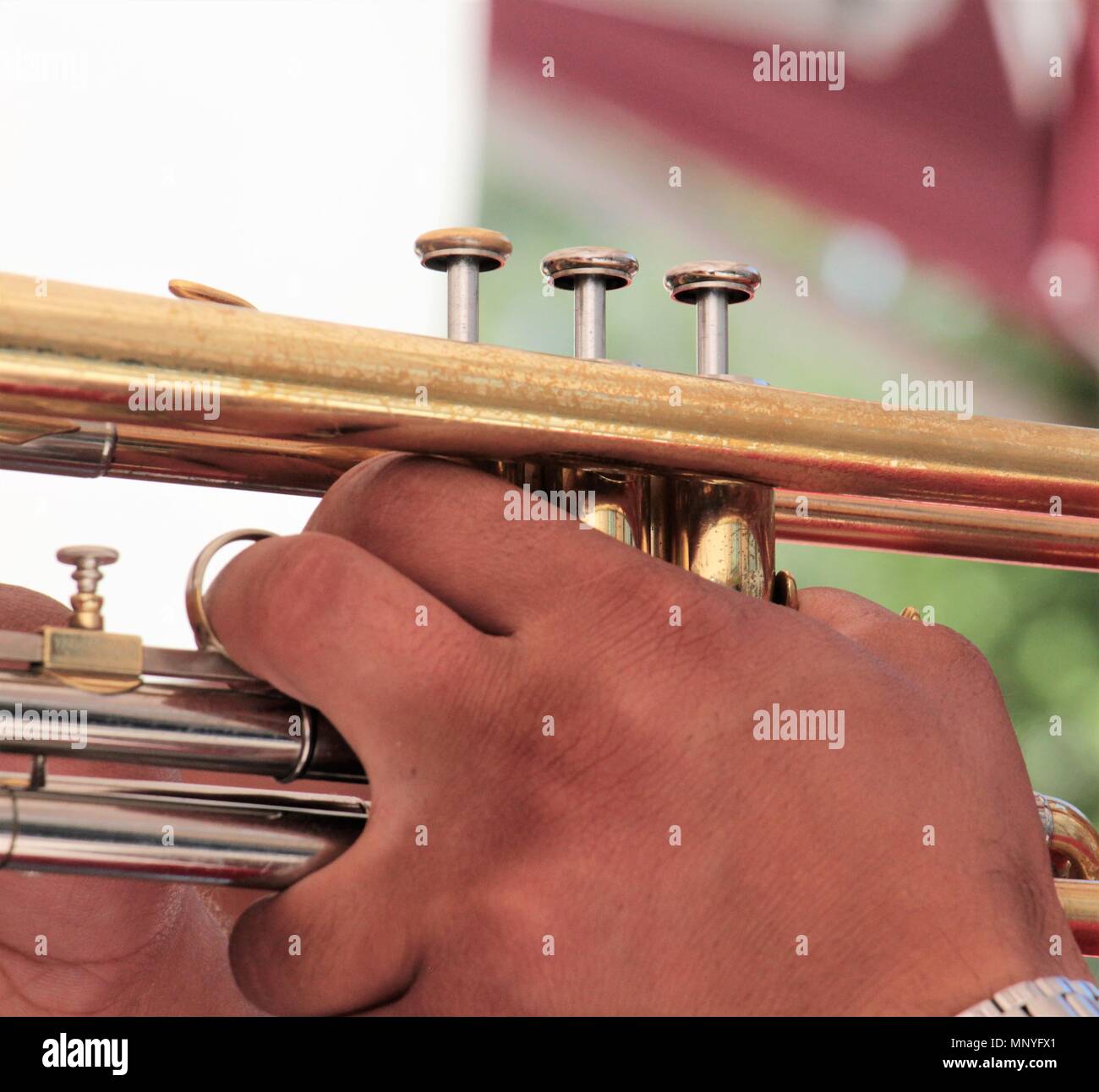 hands on a brass instrument,musicians playing outdoor,close up,image ...
