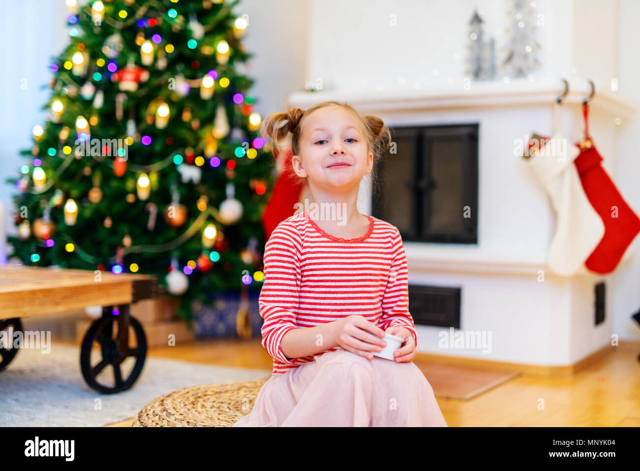 Adorable little girl at home beautifully decorated for Christmas with