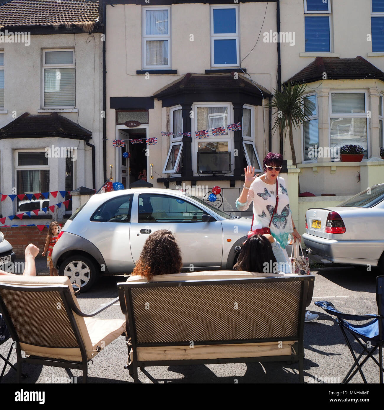 Residents sitting on sofa in street watching live coverage of the royal wedding celebrating Harry and Meghan's wedding Stock Photo