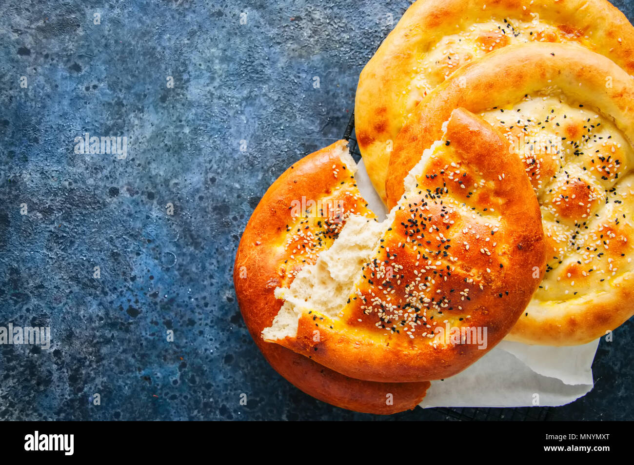 Turkish ramazan pidesi - Traditional Turkish ramadan flatbreads usually baked during ramadan month. Blue stone background. Top view. Stock Photo