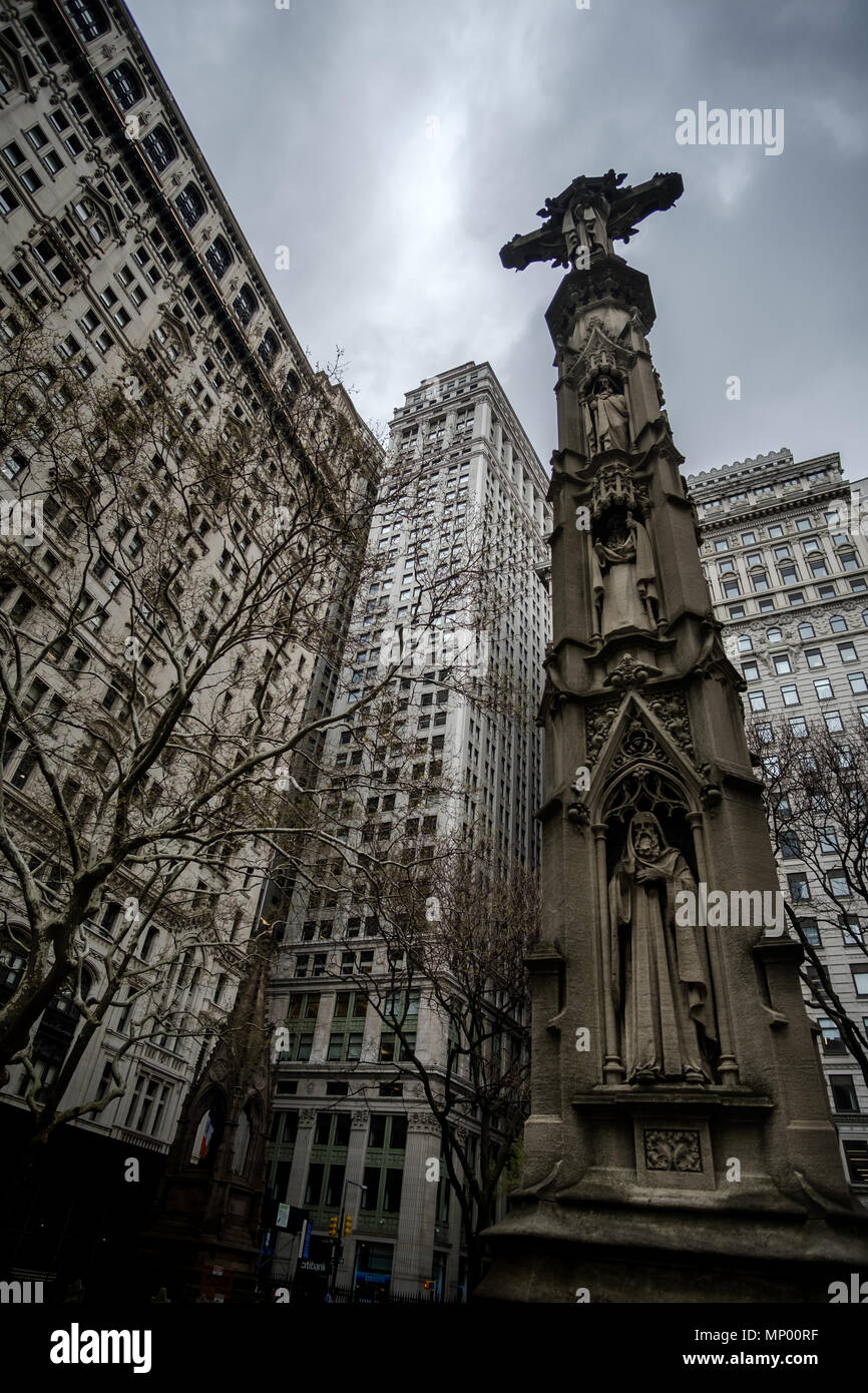 Crucifix agains buildings in the cemetery of Trinity Church in Manhattan, New York, USA. April 30, 2018. Stock Photo