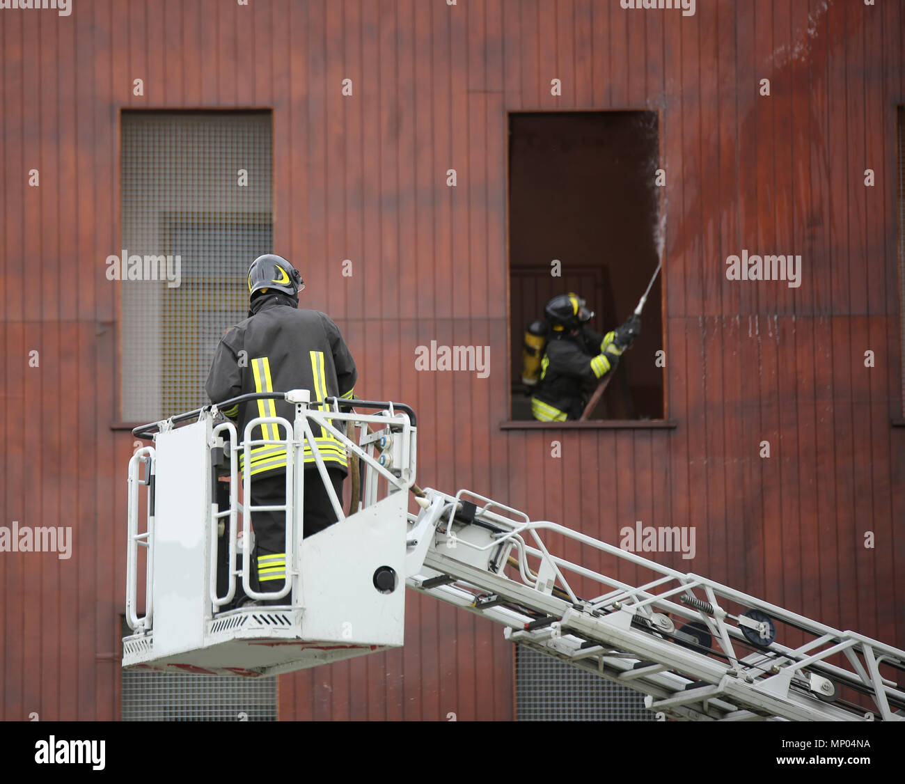 firefighter on a ladder to reach the top floors of a building and