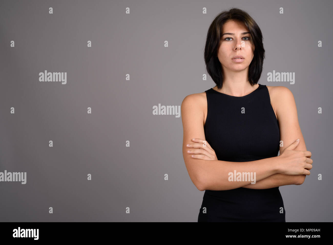 Young beautiful woman against gray background Stock Photo