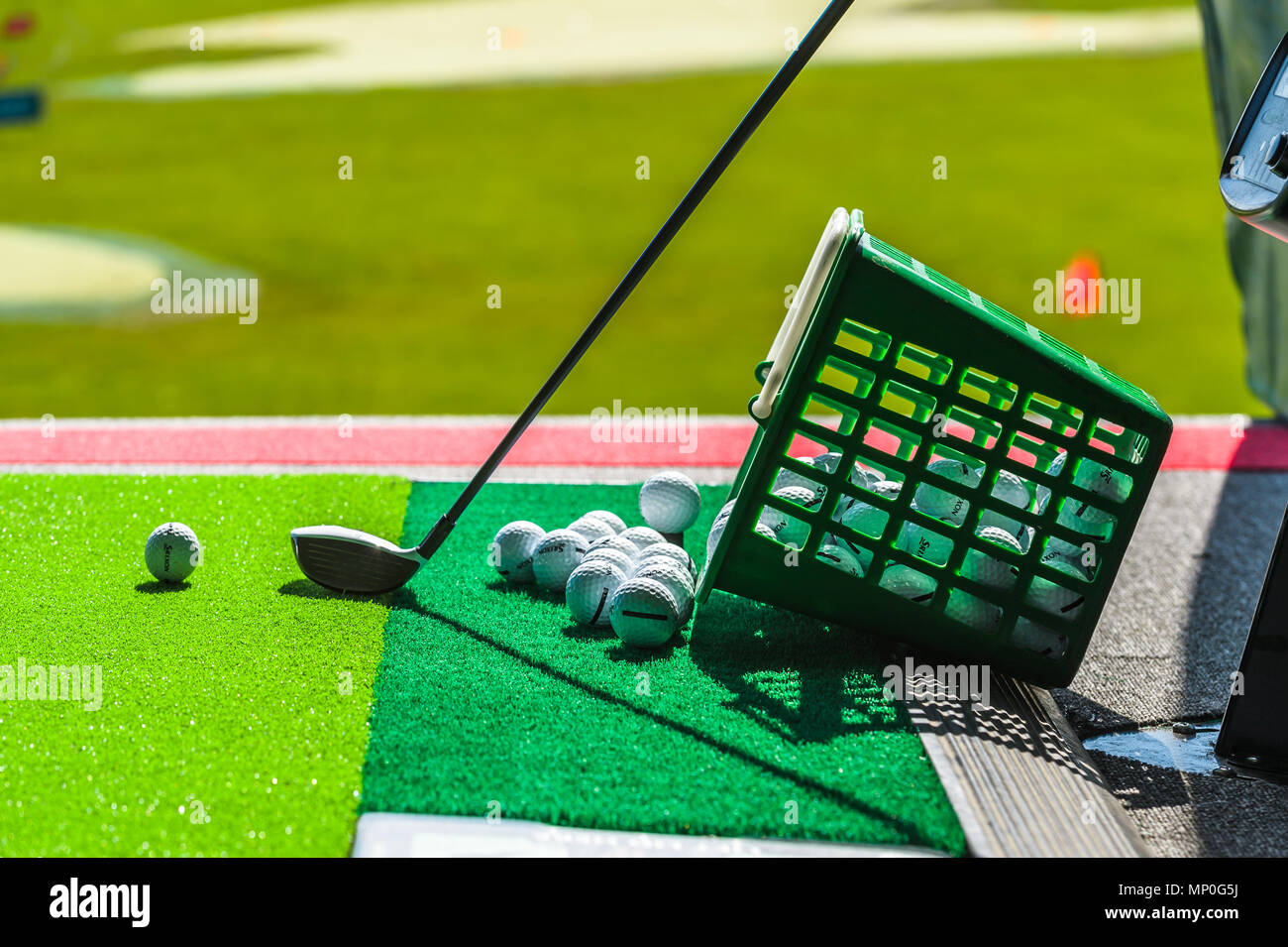 Golf balls, basket of balls & Golf clubs at driving range images Stock