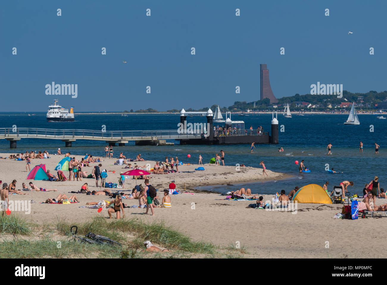 Relaxing at a hot summer day at the beach 'Falkensteiner Strand', the fjord liner coming up to the pier, Kiel Fjord, Kiel, Germany, Stock Photo