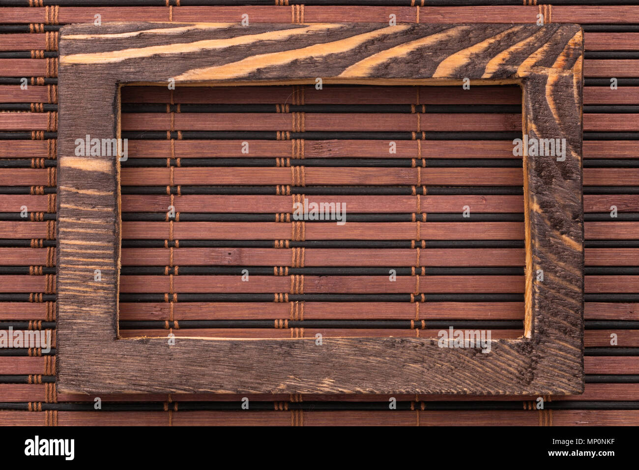 Rectangular wooden frame on a bamboo mat. View from above Stock Photo
