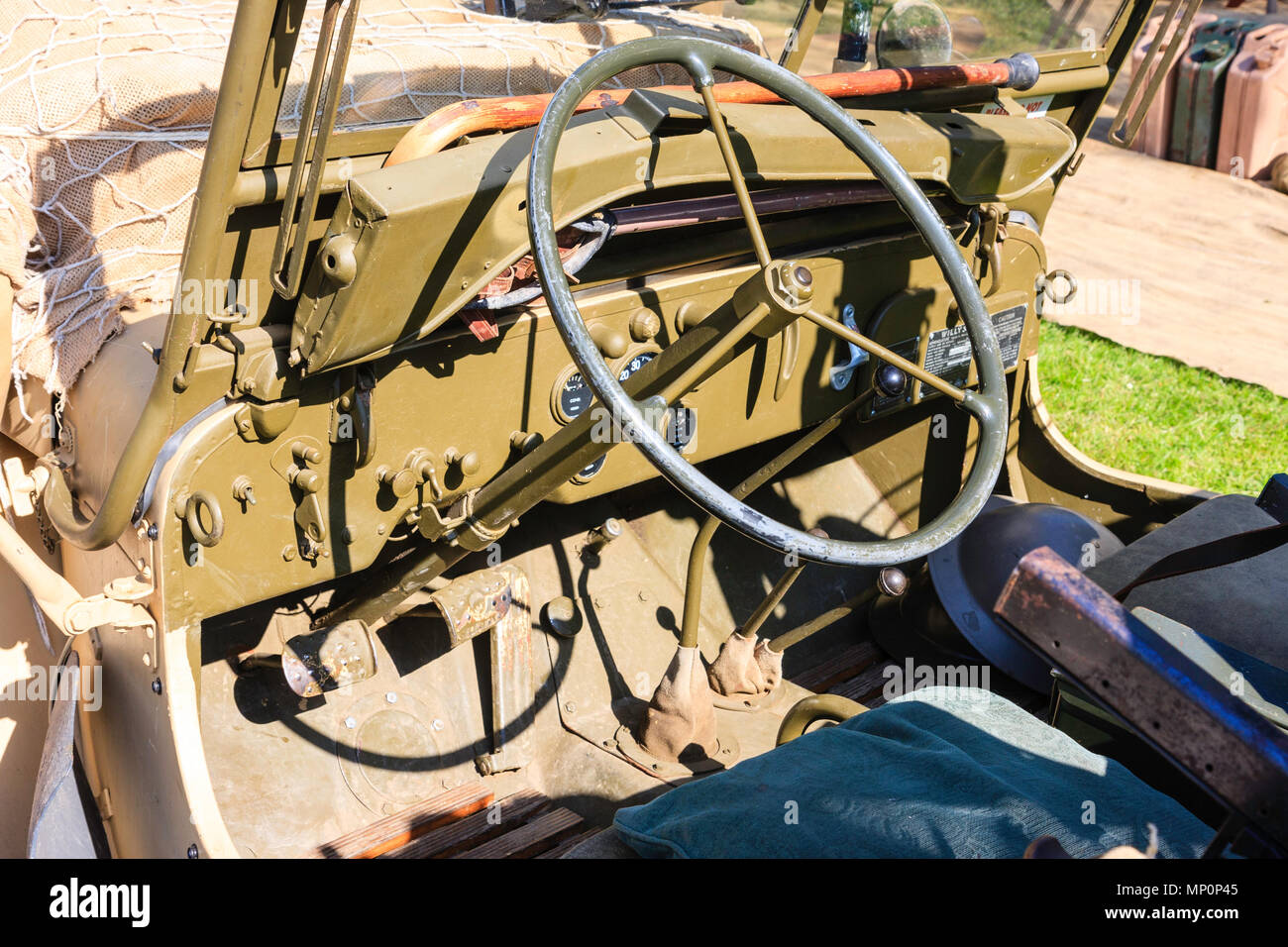World War two vintage jeep. Driving dashboard and steering wheel, low angel view from seat along dashboard. Stock Photo