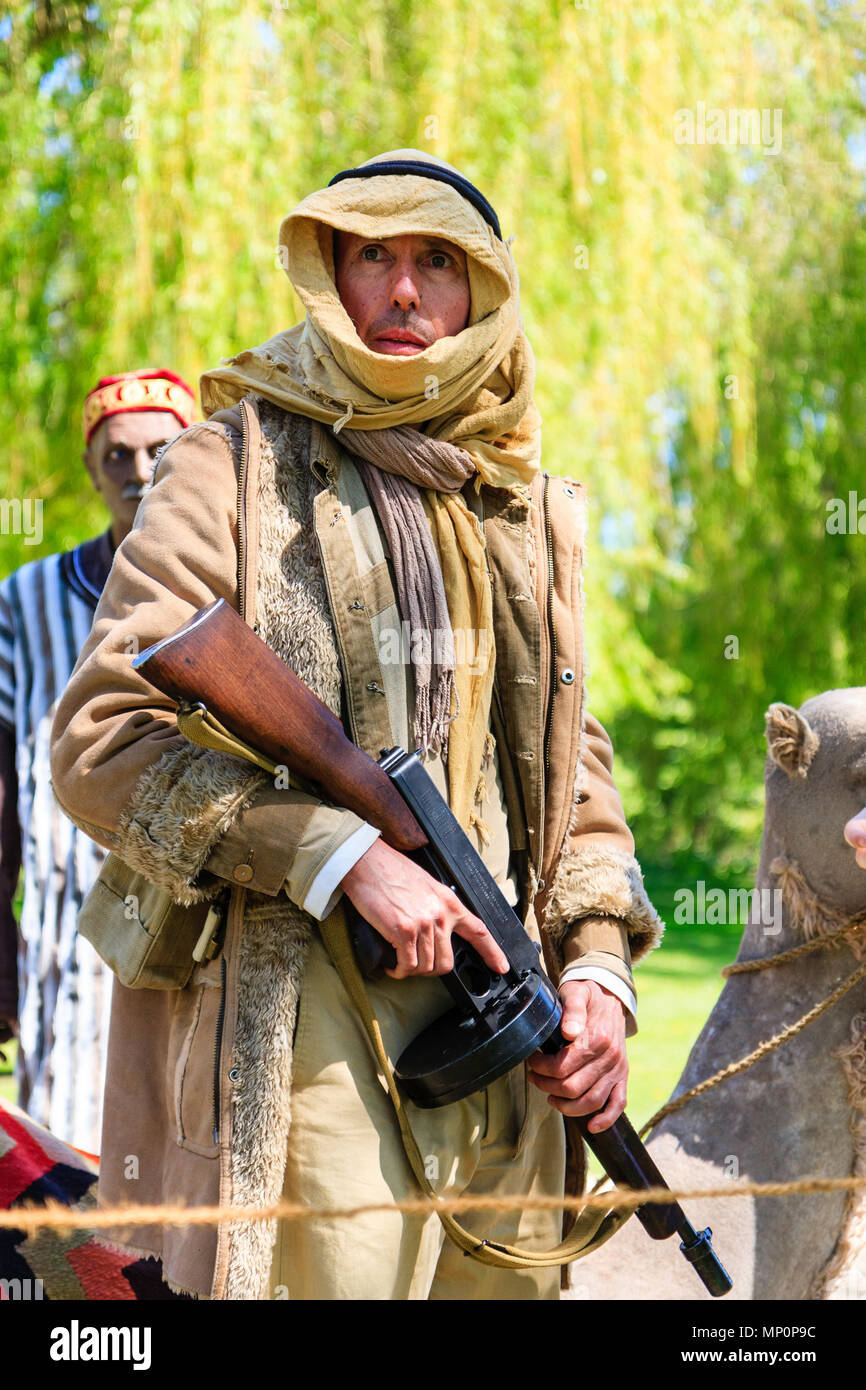 Popular Salute to the 40s event at Sandwich town, Kent. Young man Reenactor dressed as British soldier in Arab Bedouin costume, holding machine gun. Stock Photo
