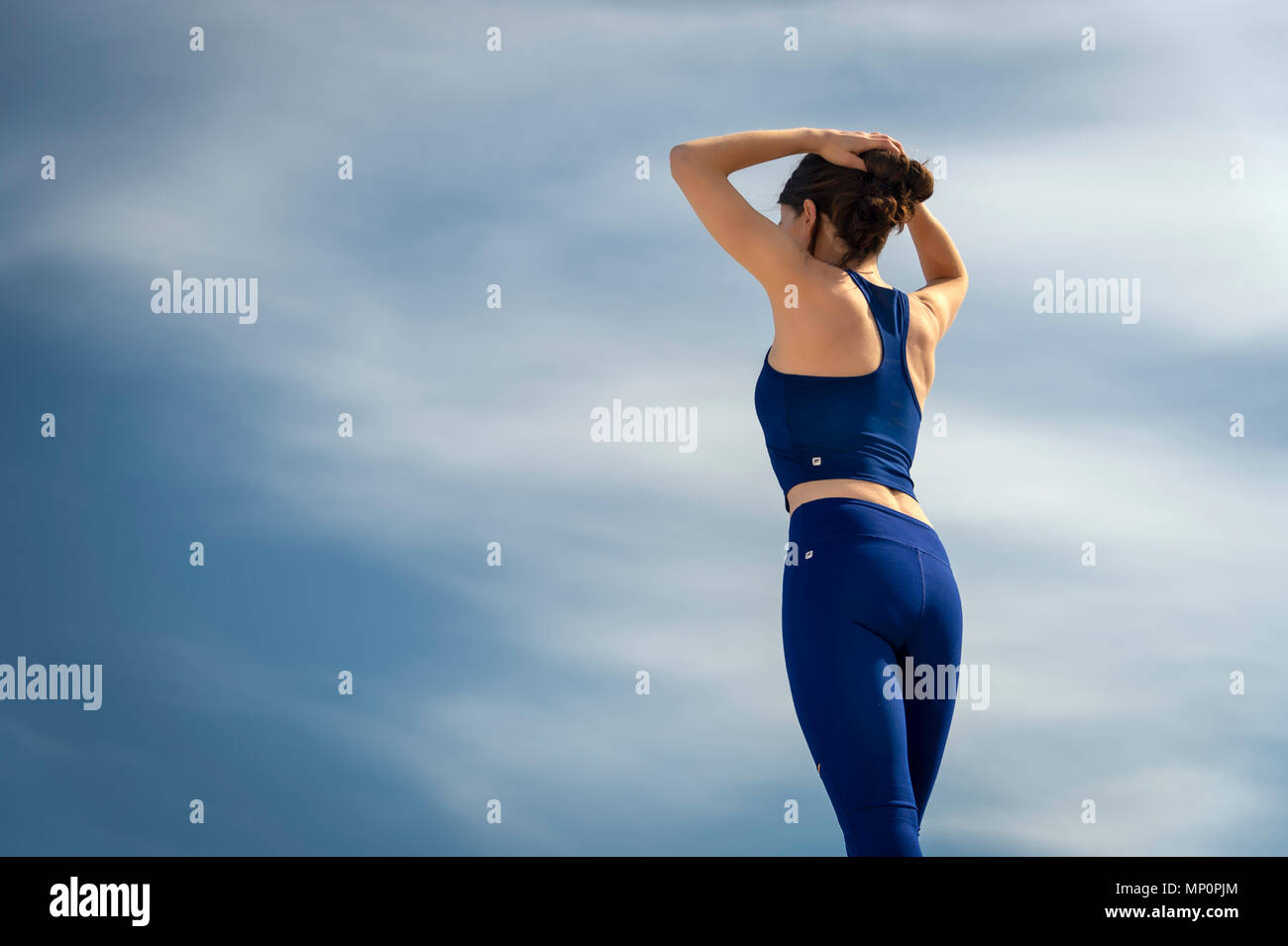 back view of a woman wearing sportswear adjusting her hair before exercising Stock Photo